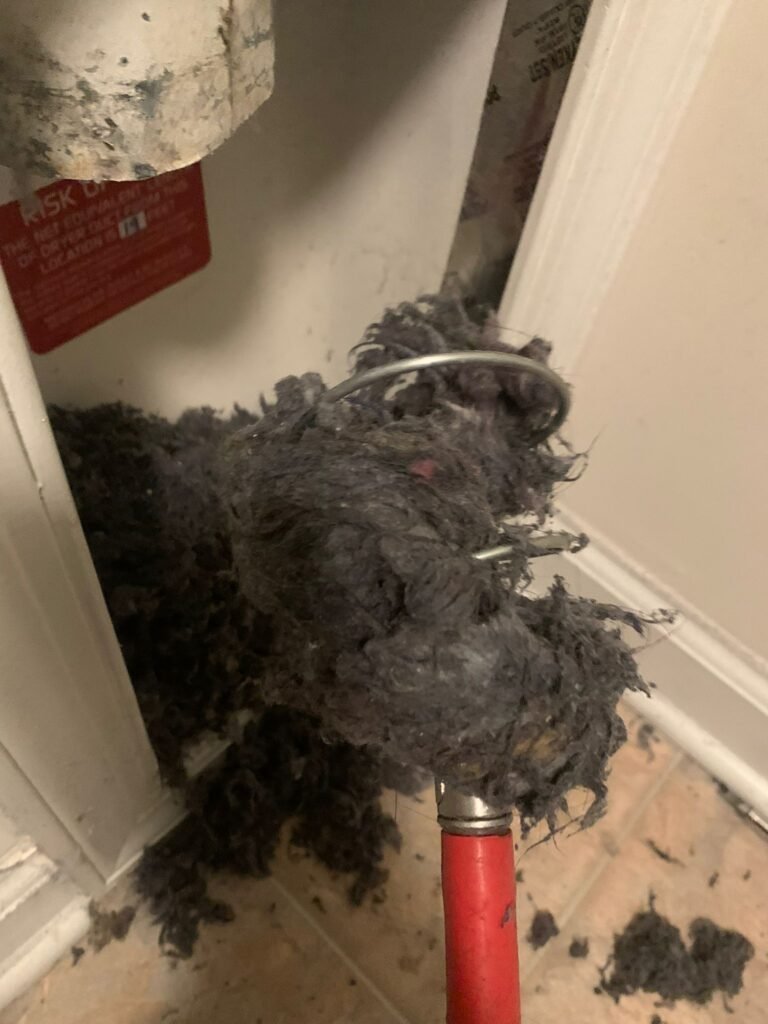 Large clump of compacted dryer lint and debris removed from behind a laundry machine. Dryer vent cleaning in Durham